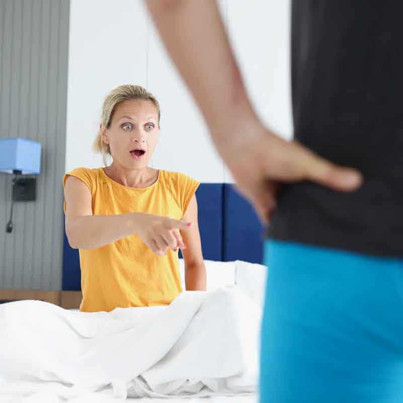 a woman looking shocked at the chastity shrinking of her husband
