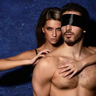g rated but kinky picture with a blindfolded young man and his mistress behind him